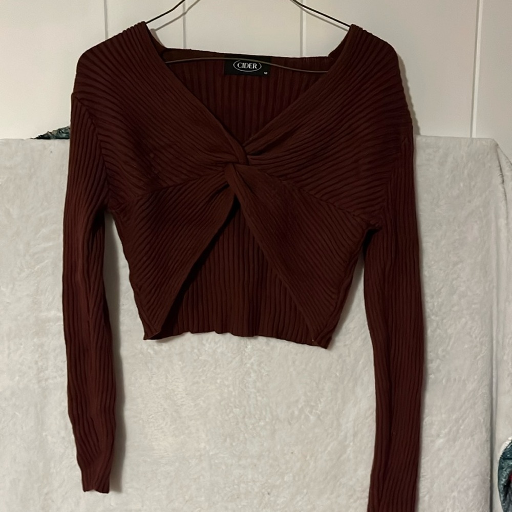 Tight fitted burgundy cardigan. Cropped, knitted material. Front woven together.